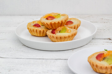 Small fruit pia cake on a textured white background. Kue Pia Buah.