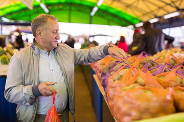 Man buying potatoes in market