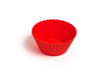 A red silicone mold for baking a cupcake on a white background