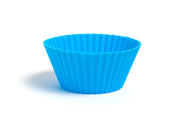 Blue silicone mold for baking a cupcake on a white background