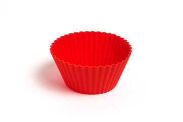 Red silicone mold for baking cupcakes on a white background