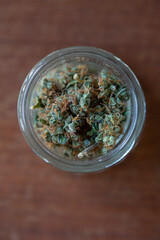 Medical cannabis sativa in a glass jar on a table.