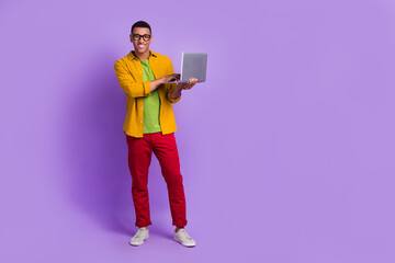 Full body portrait of cheerful person hold use wireless netbook empty space ad isolated on purple color background