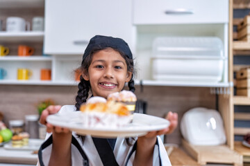 Children in learning kitchen room playing made loaf of bread put on the tray and serve