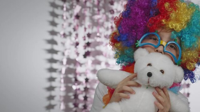 Boy of 10 years old dressed in clown's wig and eyeglasses. 