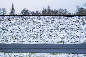 Snow-covered embankment of the tramway at footpath