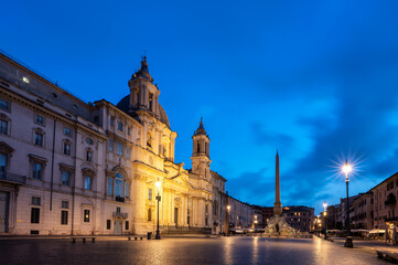 Fototapeta na wymiar Scenic view with Egyptian obelisk and Sant Agnese Church at illuminated Piazza Navona before sunrise, Rome, Italy