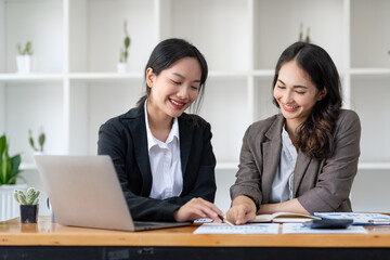 Business idea creative brainstorming sessions for projects Strategic topic of two Asian girls working together data analysis Happy clarification of various financial information at the desk.
