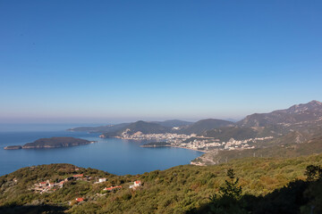 Panoramic aerial view on the coastline of Budva and Sveti Nikola Island seen from Goli Vrh, Adriatic Mediterranean Sea, Montenegro, Balkan, Europe. Luxury hotel resorts along Budvanian Riviera.