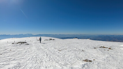 Woman hiking in snow covered landscape near Ladinger Spitz, Saualpe, Lavanttal Alps, Carinthia,...