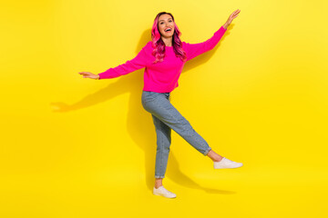 Fototapeta na wymiar Full length photo of pretty carefree lady wear vivid sweater dancing walking empty space isolated yellow color background