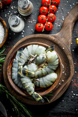 Raw shrimps with spices, tomatoes on a branch and rosemary.