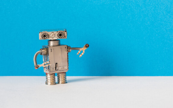 Micro robot on blue gray background, copy space