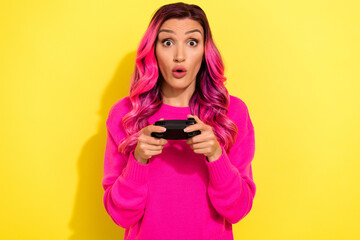 Portrait of impressed addicted lady gamer pouted lips playing video games isolated on yellow color background