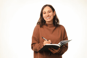 Studio portrait on white of a smart smiling at the camera woman holding a journal and a pen.