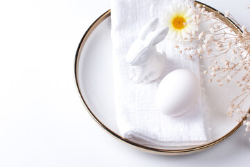 Serving the Easter table. A plate with a white napkin fork and an Easter egg on a white background