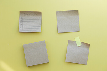 note taped recycle paper on a yellow background