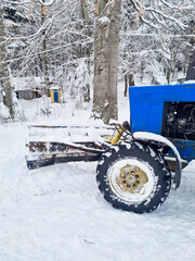 part of a blue tractor with large wheels in a snowy forest. the concept of all-terrain transport in...