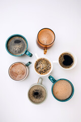 A set of mugs with different coffees on a white background. Flat lay