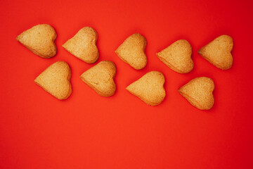 Shortbread cookies in the form of hearts on a red background. Background, Valentine's Day. Flat lay