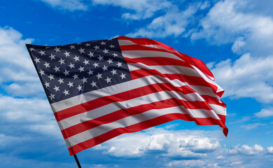 American flag on the blue sky. The American flag waving in the blue sky.