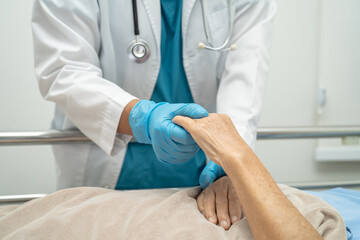 Doctor touching hands Asian senior or elderly old lady woman patient with love, care, encourage and empathy at hospital.