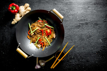 Delicious cellophane noodles in a frying pan wok with chopsticks.