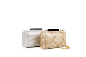 Naklejka premium Cartera plateada y cartera dorada de mujer con asas largas de cadena dorada sobre un fondo blanco liso y aislado. Vista de frente y de cerca. Copy space