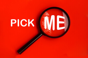 Pick me text on red background with magnifying glass. Hiring concept