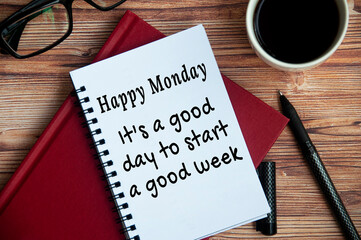 It is a good day to start a good week text on white notepad. With books, pen, coffee and glasses...
