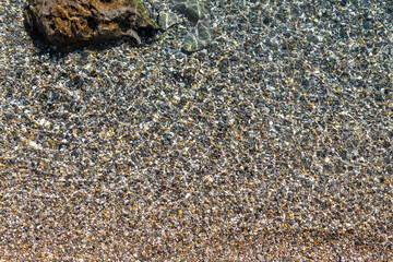 Pebbles in the sea as natural background, top view