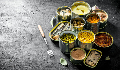 Set of different open tin cans with canned food.