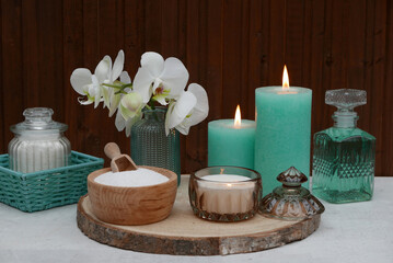 Fototapeta na wymiar Spa Arrangement mit Massageöl, Kerzen und Orchideenblüte. 