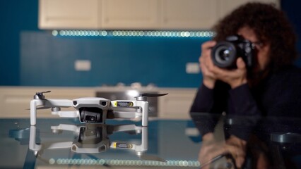 Real estate photographer takes photos and video inside house with professional camera and drone -...
