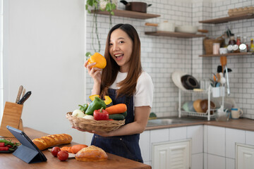 Young Asian teenage female prepare vegetable and cocking food at kitchen at home.
