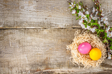 Easter mockup for text with painted eggs and spring cherry branches with flowers, top view, copy space