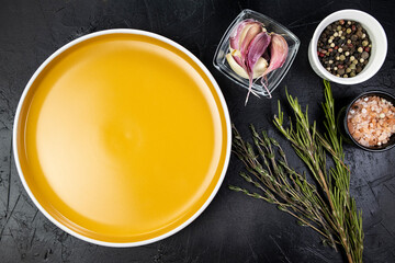 Food photo mockup, empty orange round plate spicy herbs and spices on black table, seasonings and spices top view, copy space