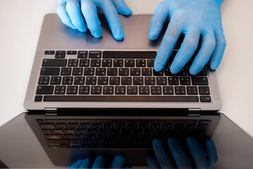 Fototapeta na wymiar Male hands in blue medical gloves working on laptop. Person works in protective medical gloves.Specialist doctor in blue latex gloves. Virus and bacteria protection, Covid-19, Healthcare concept.