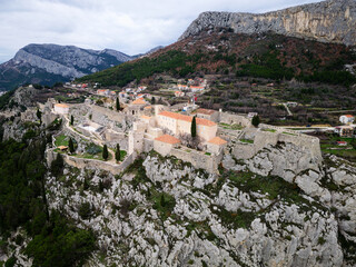Fototapeta na wymiar The Klis Fortress is a medieval fortress situated above a village bearing the same name, near Split, Croatia. Places of historic interest. Medieval fortress built into a rocky ridge.