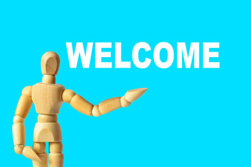 Background concept. The inscription Welcome on a blue background. Wooden model of a man.