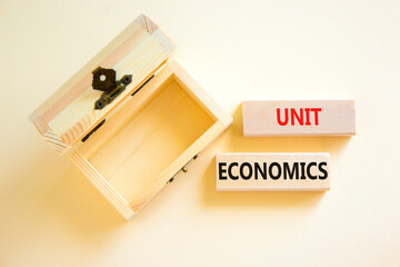 Unit economics symbol. Concept words Unit economics on wooden blocks. Beautiful white table white background. Wooden empthy chest. Business and unit economics concept. Copy space.