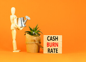 Cash burn rate symbol. Concept words Cash burn rate on wooden blocks on a beautiful orange table...
