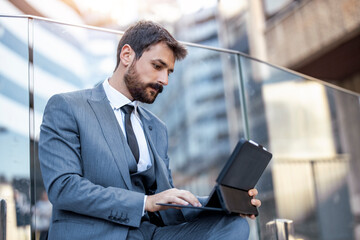 Young businessman using a digital tablet outdoors