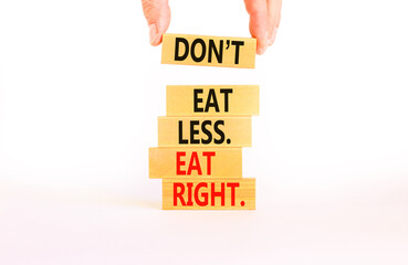 Eat less or right symbol. Concept words Do not eat less, eat right on wooden blocks. Beautiful white table white background. Doctor hand. Healthy lifestyle and eat less or right concept. Copy space.