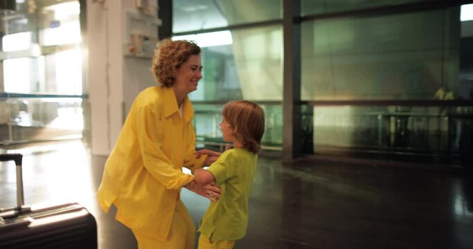 The long-awaited meeting of mother and son at the airport. The son runs to his mother, who has returned from a business trip. Businesswoman, happy mother lifts her beloved son in her arms and spins.