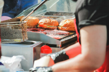 Burger cooking outdoors. Fast food restaurant with french fries and burgers.