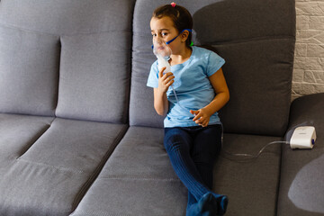 Little girl use inhaler nebulizer. Child asthma inhaler, nebulizer steam, flu or cold concept. Copyspace