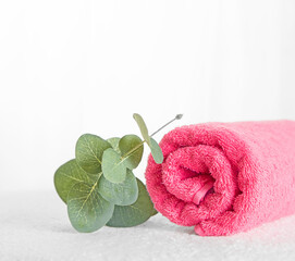 Spa set pink towel and eucalyptus branch close-up on a light background