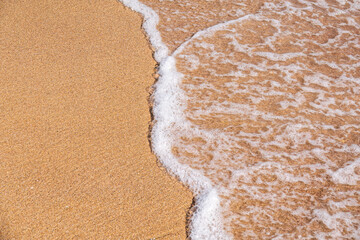 Soft wave of the sea on the sandy beach.