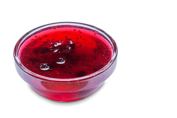 small glass bowl with currant jam on a white background